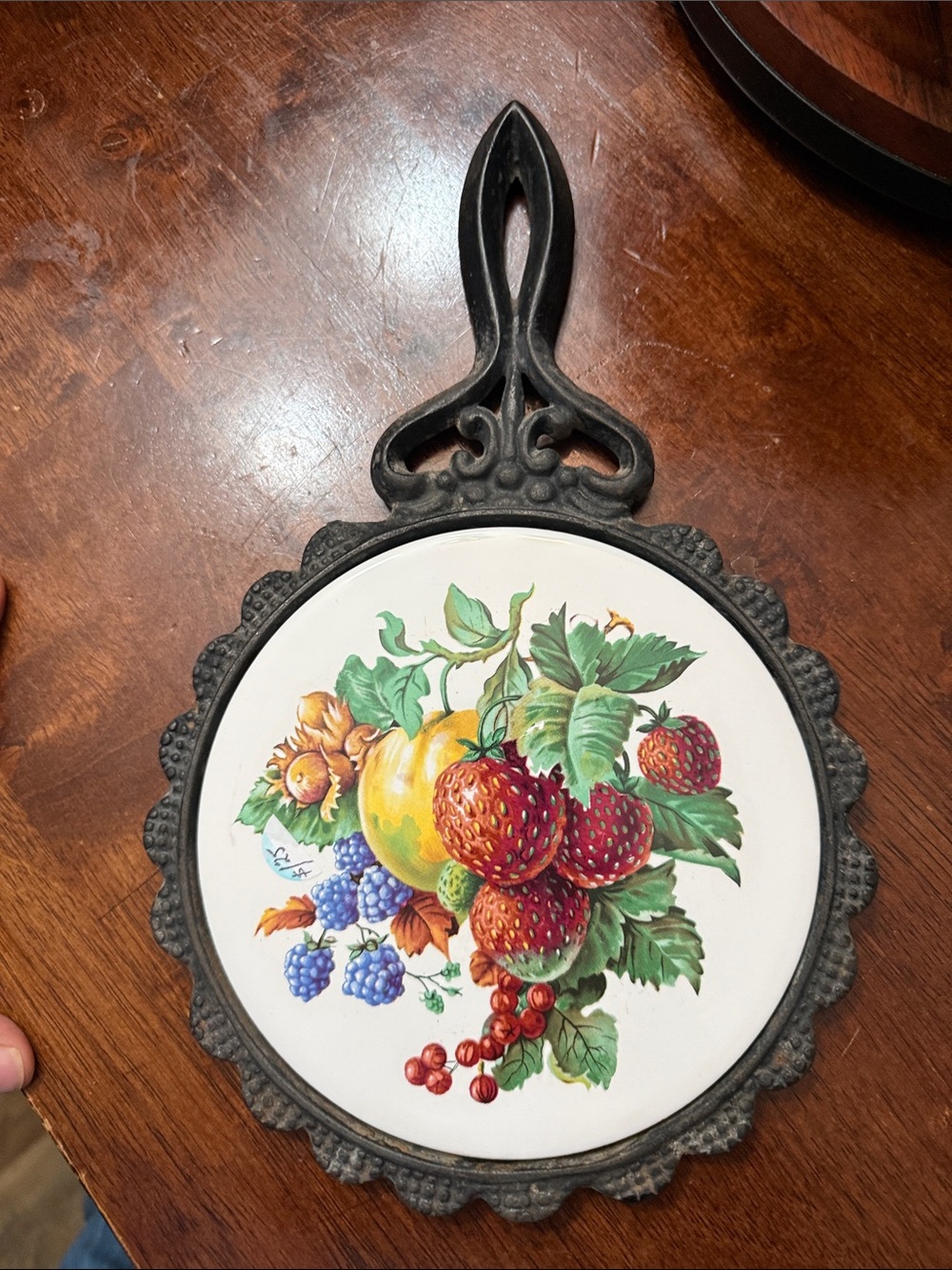 Charming Vintage cast iron trivet featuring a charming ceramic tile center color
